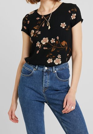 Schwarzes florales Oberteil mit kurzen Ärmeln, verziert mit pinken und cremefarbenen Blumen, kombiniert mit hoch taillierter blauer Denim-Jeans mit Taschen.