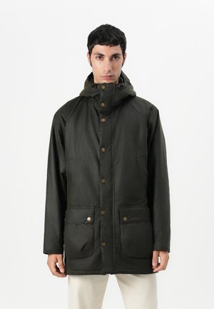 Casaco impermeável verde-escuro com um colarinho alto, botões de pressão e dois bolsos frontais. Apresenta uma textura suave e um design casual.