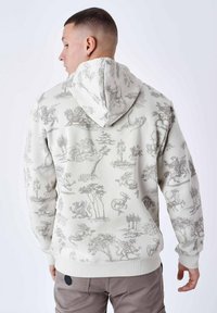 Felpa con cappuccio di colore beige chiaro, decorata con motivi di drago grigio e paesaggi, dotata di cappuccio con cordino e polsini e orlo a costine.