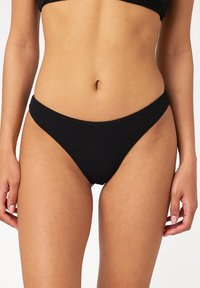 Czarny dół bikini z teksturowanej tkaniny, średnio wysoki stan i mocno wycięte nogawki, zaprojektowany z myślą o dopasowanej sylwetce. Bez widocznych wzorów czy metalowych elementów.