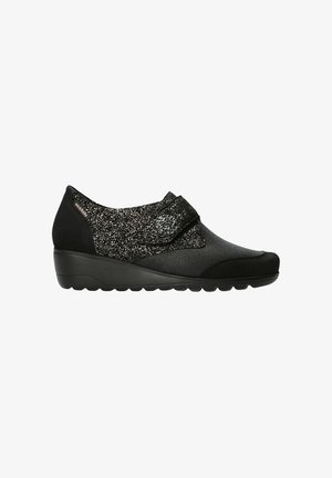 Zapato de cuña negro con cuero texturizado y tela brillante, con una correa con hebilla floral y suela de goma para comodidad y soporte.