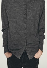 Dark gray button-up shirt made of textured fabric with a straight cut, featuring a full button closure and long sleeves.