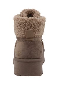 Bottines en daim marron avec un col en shearling duveteux et texturé et une languette à l'arrière. Semelle en caoutchouc épaisse pour une meilleure adhérence.