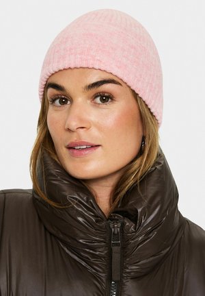Hellrosa, gerippte Strickmütze mit einem schlichten Design, kombiniert mit einer glänzenden, dunkelbraunen, nahtlos geschlossenen Steppjacke mit hohem Kragen.