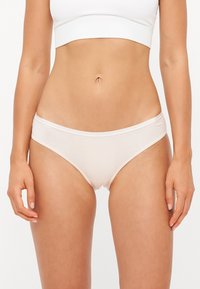 Beige cotton panties with a smooth texture and elastic waistband featuring a subtle brand logo. Simple, classic design, with minimal coverage.