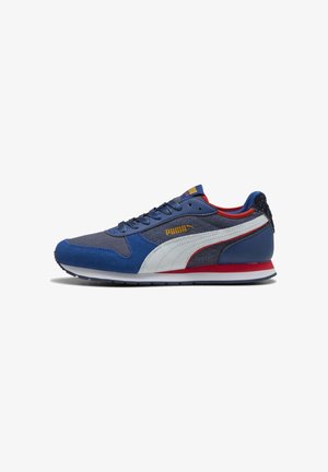 Zapatilla deportiva azul con materiales de ante y malla, que presenta una franja blanca, acentos rojos y un talón texturizado. Incluye un diseño con cordones.