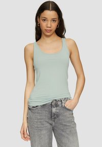 Lichtblauwe tanktop van zacht materiaal met een ronde halslijn, gecombineerd met vervaagde grijze jeans, die een casual pasvorm en zijzakken heeft.