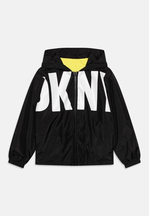 Czarna kurtka z kapturem zapinana na zamek z przodu, duży biały napis "DKNY" na piersi oraz żółte wnętrze kaptura.