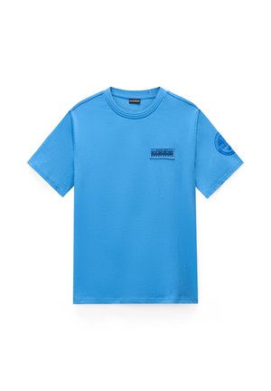 Jasnoniebieska koszulka z krótkim rękawem i okrągłym dekoltem, z małą prostokątną naszywką z logo na piersi oraz okrągłym logo na lewym rękawie.