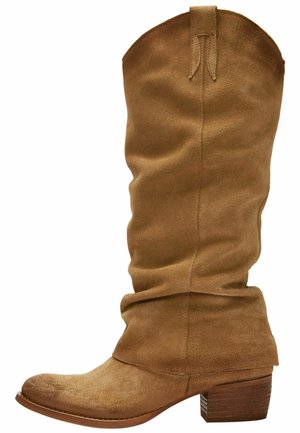 Tan suède kniehoge laarzen met een versleten ontwerp, ronde neus en een gestapelde houten hak. De bovenkant heeft een trekstrip voor gemakkelijke aantrekking.