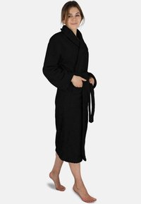 Schwarzer Frottee-Bademantel, knielang mit einem Gurt in der Taille, großen Taschen, verlängerten Revers und einer weichen, strukturierten Oberfläche.