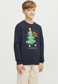 Sötétkék pulóver, amelyen egy színes rajzfilm karácsonyfa grafika látható a "HOLLY JOLLY" felirattal. Puha anyagból készült; bordázott mandzsettákkal és szegéllyel.