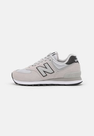 Gray and white New Balance sneaker with black "N" logo, lace-up, and cushioned sole, side view on a plain white background.
