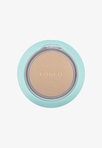 Kompaktfoundation med mintgrønn skall, gjennomsiktig lokk og lysebrunt pudder inni. Har preget "FOREO"-logo.