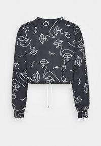 Sudadera negra recortada con dibujos abstractos en blanco de rostros y plantas. Presenta mangas largas y un detalle de cordón en el dobladillo.