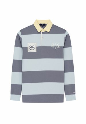 Camisa de rugby de manga larga con amplias franjas horizontales en gris y azul claro, cuello amarillo, parche con el número "85" y emblema de remos cruzados en el pecho.