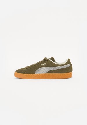 Dark green suede sneaker with a silver Puma stripe, brown laces, and an orange rubber sole. Low-top design with a cushioned collar.
