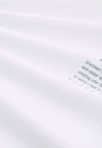 Tela blanca con una textura suave, que muestra texto impreso en una fuente sans-serif. El texto incluye "Desvinculación de tareas relacionadas con el trabajo."