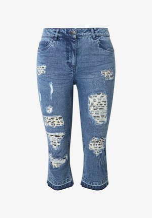 Vaqueros de mezclilla azul con textura desgastada, que presentan grandes desgastes y una capa inferior con estampado de leopardo, recortados a la altura de la pantorrilla con un dobladillo tipo puño.