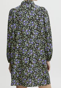 Svart blommig klänning med lila blommor och gröna blad, med långa puffärmar och krage. Lättviktigt tyg.