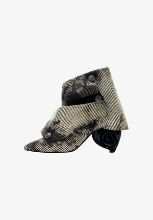 Asimetrična čizma do gležnja od prugastog materijala, koja ima crni skulpturalni potplat, u sivoj i bež boji, sa detaljima od dugmadi i teksturiranom površinom.