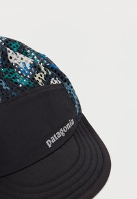 Μαύρο καπέλο Patagonia με σχέδια, από διχτυωτό ύφασμα και καμπύλη γείσο, σε λευκό φόντο.