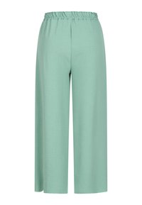 Pantalon ample vert menthe avec une ceinture élastique et des jambes larges, fabriqué en tissu léger texturé.