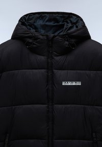 Chaqueta tipo puffer negra con un diseño acolchado, que cuenta con capucha, cierre de cremallera y un logo de la marca en el pecho. Textura suave, material aislante.