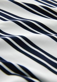 Tissu rayé avec des lignes alternées bleu marine et blanches, présentant une texture lisse et un léger éclat, idéal pour les vêtements ou les textiles d'ameublement.