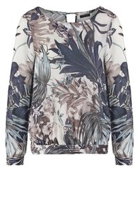 Blouse à manches longues avec ourlet élastique, présentant un imprimé tropical discret de grandes feuilles et fleurs dans des tons de bleu, gris et marron.