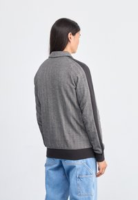 Puma Jaka ar rāvējslēdzēju - black alpine snow