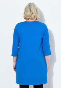 Tunic blu con scollo rotondo e maniche a tre quarti, realizzata in tessuto morbido, caratterizzata da un design semplice e senza decorazioni, dal taglio comodo.