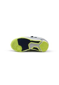 Suela de zapato atlético con un caucho negro texturizado y acentos en verde. El diseño incluye ranuras y patrones circulares para tracción.