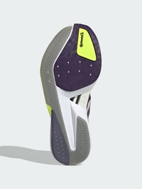 Sola do sapato com design em borracha padrão roxo, acento amarelo e uma entressola branca com o texto "ADIZERO" e detalhes texturizados.