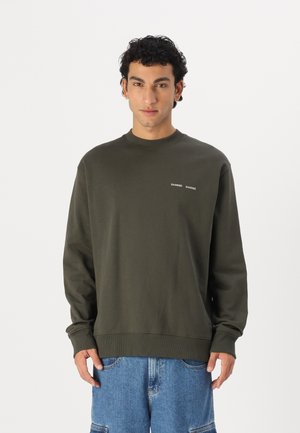 Olive green sweatshirt with a crew neck and ribbed cuffs, featuring white text branding on the chest. Smooth texture and relaxed fit.