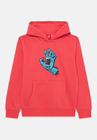 Sweatshirt cor-de-rosa com um bolso frontal; apresenta um gráfico azul de uma mão com uma boca aberta, destacando cores vibrantes e um design de estilo cartoon.