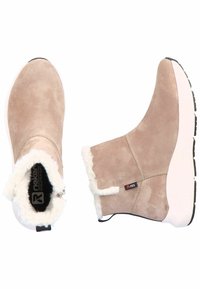 Bottines en suède beige avec garniture en fausse fourrure, bout arrondi et semelle en caoutchouc noir. Fermeture éclair sur le côté ; marque visible à l'intérieur.