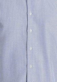 Camicia a righe blu e bianche con colletto classico, dotata di piccoli bottoni e realizzata in un tessuto di cotone leggero.