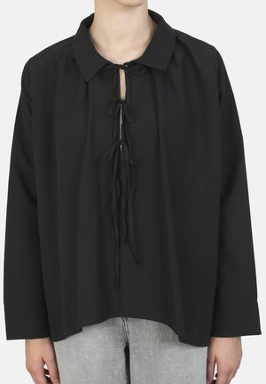 Black blouse with a collar and front ties, featuring long sleeves and a loose fit. Soft fabric with a smooth texture.