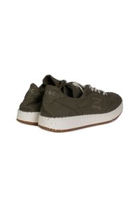 Sneakers in tela verde oliva con suole in gomma bianca, collare imbottito e cuciture a contrasto. Presentano lacci e un branding sottile di lato.