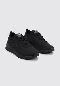 Zapatos deportivos negros de material de punto con una parte superior texturizada, cierre de cordones y una suela de goma sólida con un diseño ligeramente curvado.