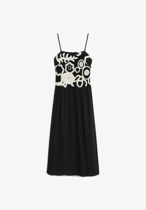 Czarna sukienka na ramiączkach, z teksturowanym białym haftowanym wzorem na górze oraz marszczonym dołem.