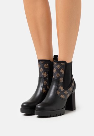 Czarne botki do kostki z grubym obcasem, z teksturowaną boczną częścią z złotym wzorem oraz elastycznymi wkładkami ułatwiającymi zakładanie.
