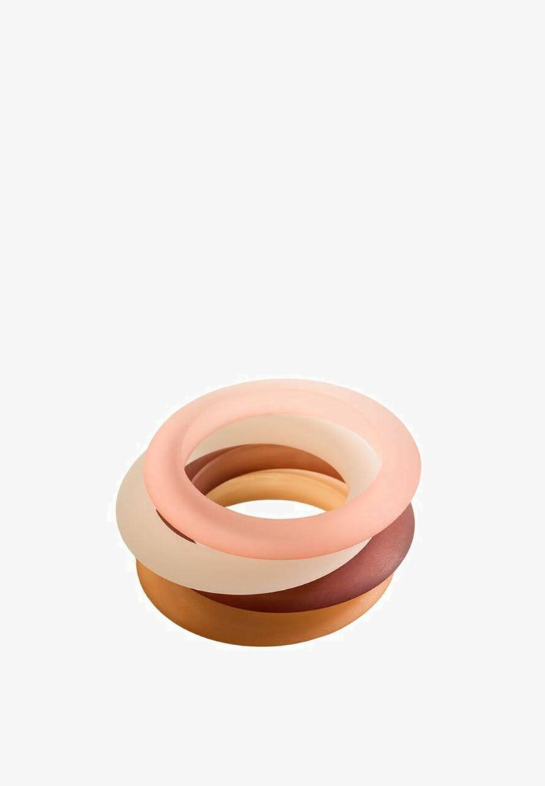Silikonové prsteny naskládané v různých odstínech broskvové, tělové a hnědé; hladký povrch s zaoblenými okraji a konzistentním kruhovým tvarem.