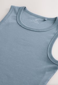 Top con spalline larghe blu a coste, con scollatura rotonda, realizzato in tessuto morbido, caratterizzato da una texture sottile e un design minimalista.