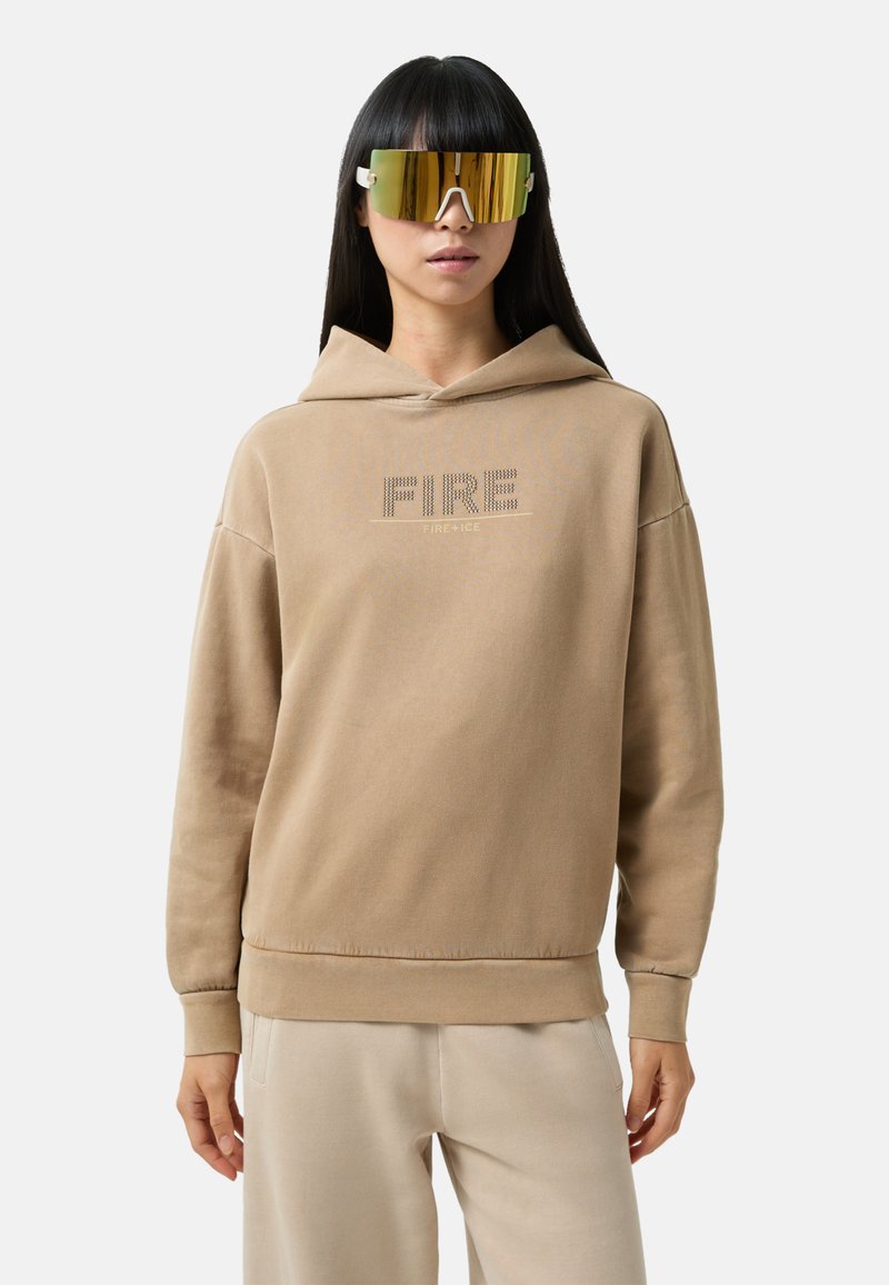 Beżowa bluza z kapturem o luźnym kroju, z napisem "FIRE" wykonanym z cyrkonii, w połączeniu z oversize'owymi, odblaskowymi okularami przeciwsłonecznymi. Miękki materiał, minimalistyczny design.