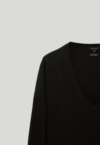 Czarny bawełniany sweter z dekoltem w serek, z długimi, luźnymi rękawami i ryflowanym kołnierzykiem. Prosty design, odpowiedni na co dzień.