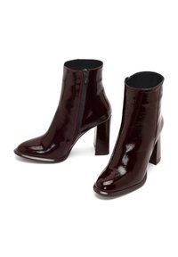 Stivaletti in pelle verniciata bordeaux con zip laterale, punta quadrata e tacco spesso. La texture liscia e il design elegante mettono in risalto un'eleganza moderna.