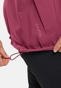 Water-resistant jacket in deep pink with textured fabric. Features adjustable drawcord at the hem and "TEXAPORE" branding.