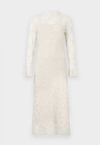 Pitkähihainen valkoinen pitsimekko aaltoilevalla kuviolla, korkealla kaula-aukolla ja puoliläpinäkyvällä kankaalla sisävuoren päällä, esitetty yksinkertaisella taustalla.